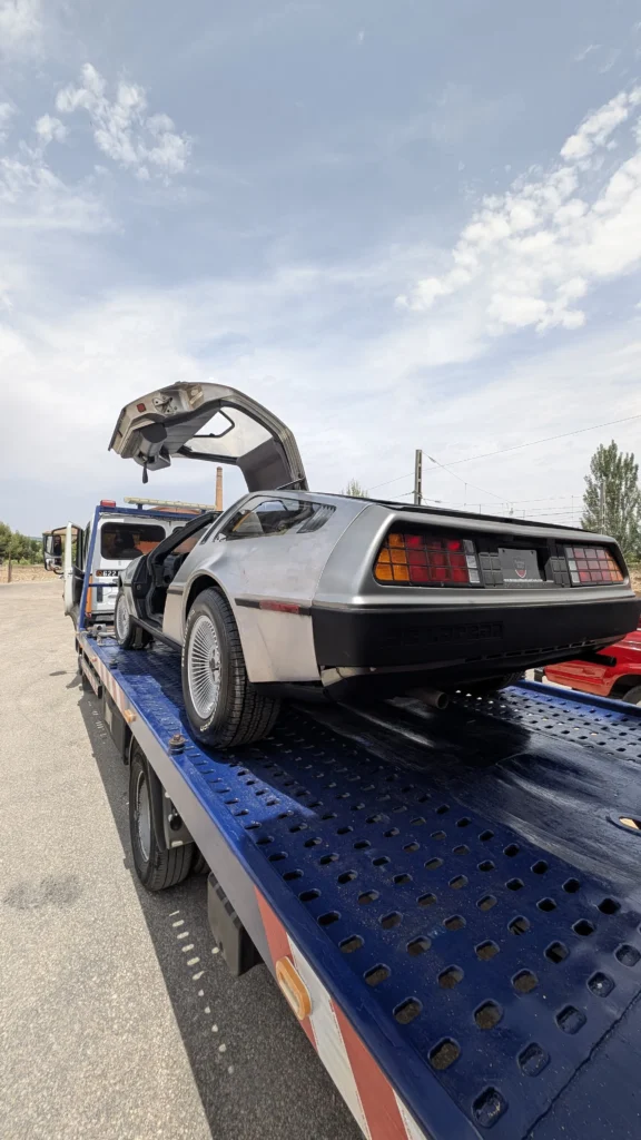 Coche clásico cargado en una grúa de plataforma