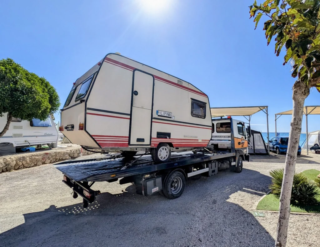 Caravana cargada en una plataforma de Grúas Alacrant en la provincia de Alicante