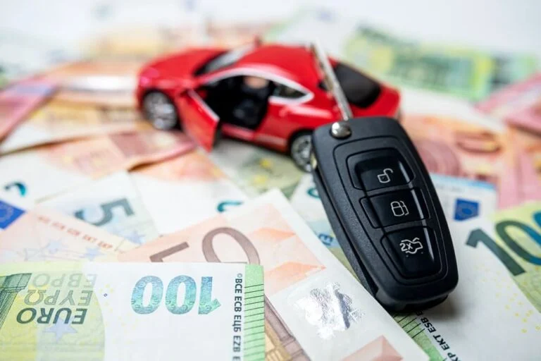 Coche de juguete, llave de coche y billetes de euro